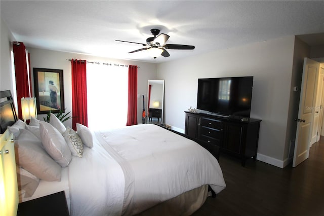 bedroom featuring a ceiling fan, baseboards, and wood finished floors