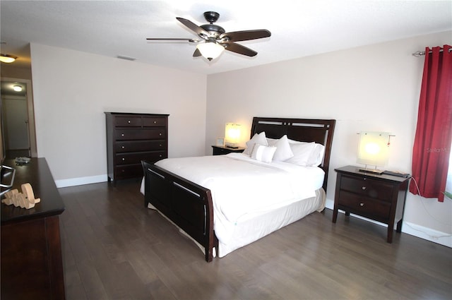 bedroom featuring a ceiling fan, visible vents, dark wood finished floors, and baseboards