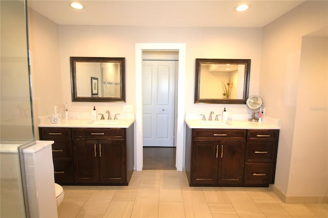 bathroom with recessed lighting, two vanities, and a sink