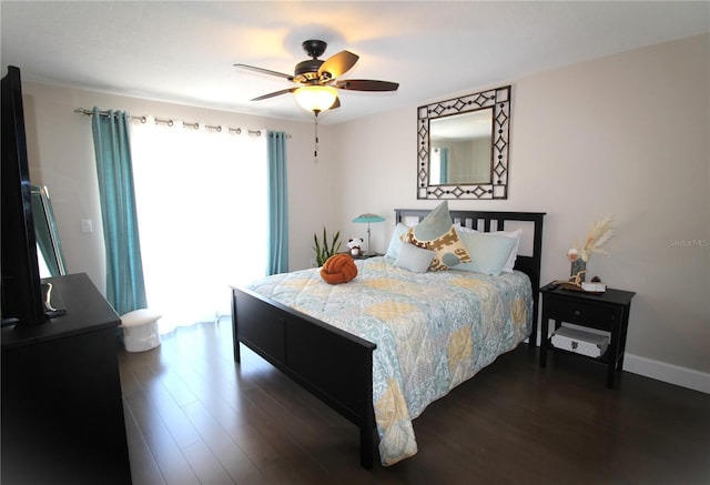 bedroom featuring baseboards, dark wood finished floors, and a ceiling fan