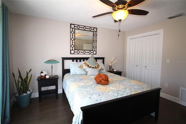 bedroom featuring baseboards, visible vents, ceiling fan, dark wood-style flooring, and a closet