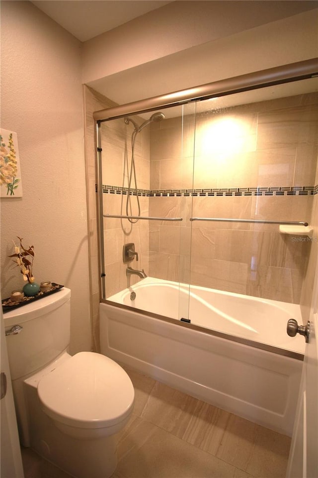 bathroom with toilet and bath / shower combo with glass door