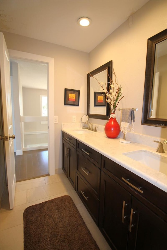 bathroom featuring double vanity, tile patterned flooring, and a sink