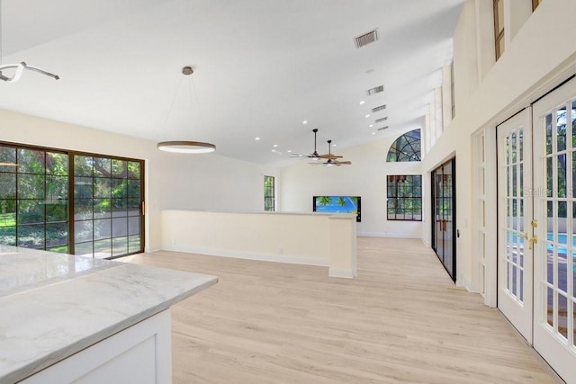 unfurnished room with a healthy amount of sunlight, french doors, and light hardwood / wood-style floors