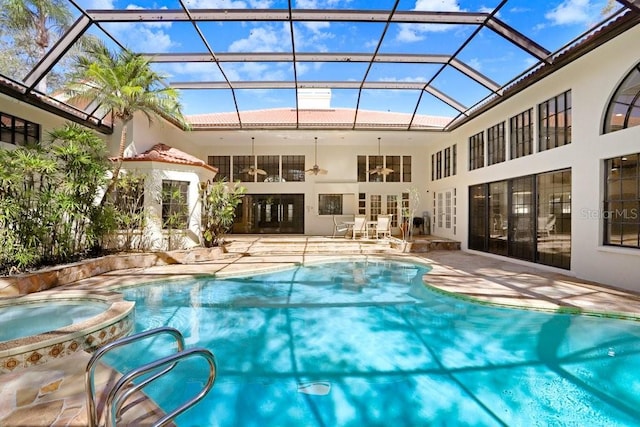 view of swimming pool with an in ground hot tub, a lanai, a patio area, and french doors