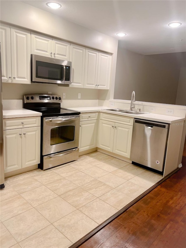 kitchen featuring sink, stainless steel appliances, and white cabinetry