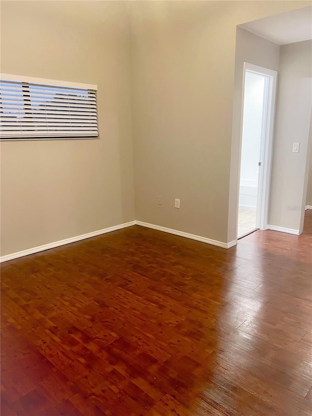 unfurnished room with dark hardwood / wood-style flooring