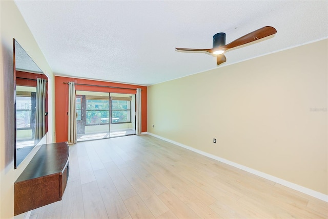 empty room with a textured ceiling, ceiling fan, and light hardwood / wood-style flooring