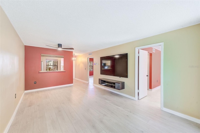 unfurnished living room with light wood-type flooring, ceiling fan, and a textured ceiling