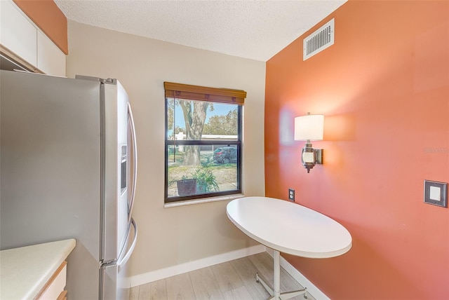 bathroom with hardwood / wood-style floors and a textured ceiling