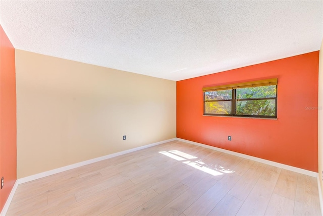 spare room with light hardwood / wood-style flooring and a textured ceiling