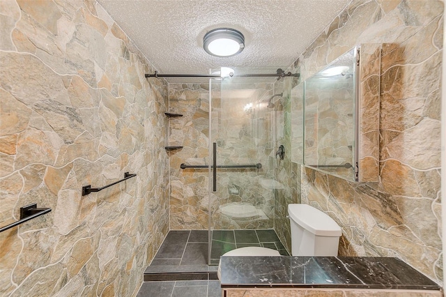 bathroom with a tile shower and a textured ceiling