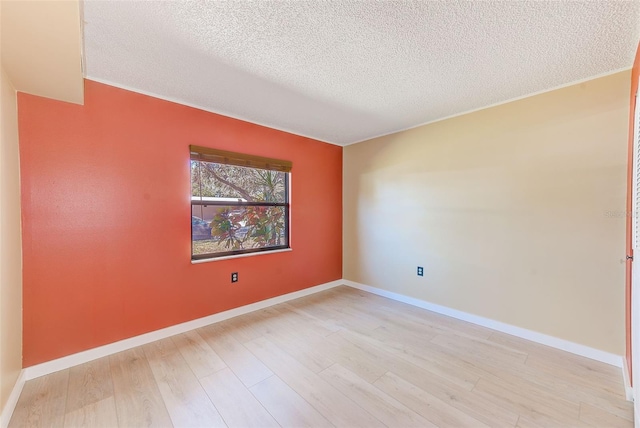 unfurnished room featuring light hardwood / wood-style flooring and a textured ceiling