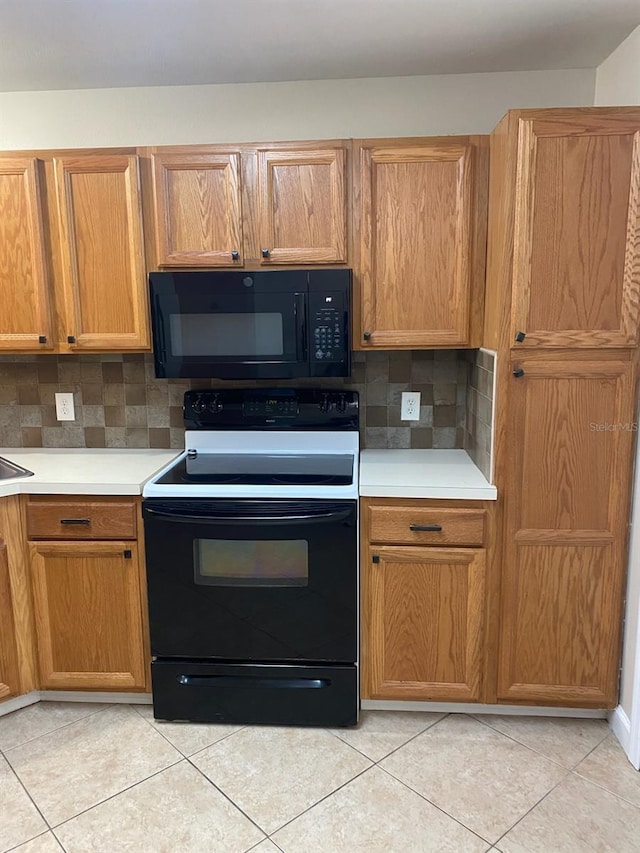 kitchen featuring black appliances, light tile patterned flooring, and decorative backsplash