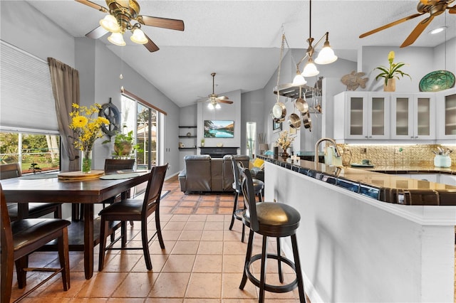 13542 Summerwood Ct, Hudson, FL 34667 - kitchen featuring lofted ceiling, decorative light fixtures, light tile patterned flooring, white cabinetry, and kitchen peninsula