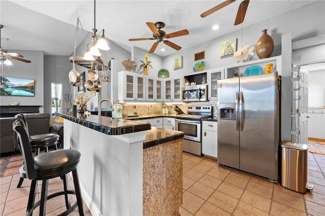 13542 Summerwood Ct, Hudson, FL 34667 - kitchen with backsplash, white cabinetry, a kitchen breakfast bar, stainless steel appliances, and kitchen peninsula