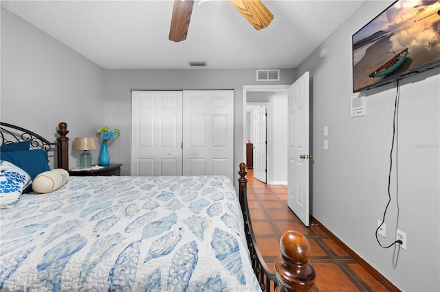 13542 Summerwood Ct, Hudson, FL 34667 - tiled bedroom with a closet, ceiling fan, and a textured ceiling