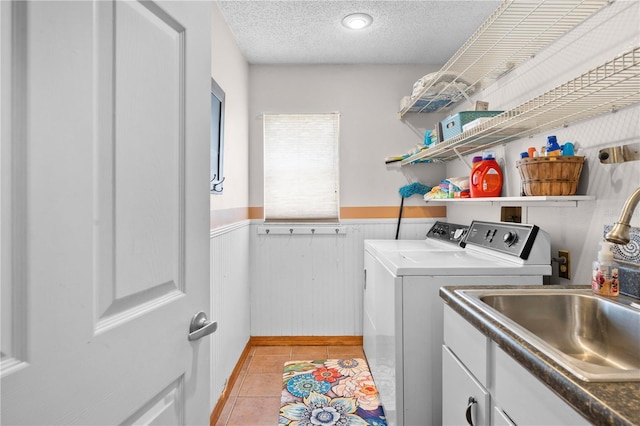 13542 Summerwood Ct, Hudson, FL 34667 - clothes washing area featuring a textured ceiling, light tile patterned floors, sink, separate washer and dryer, and cabinets