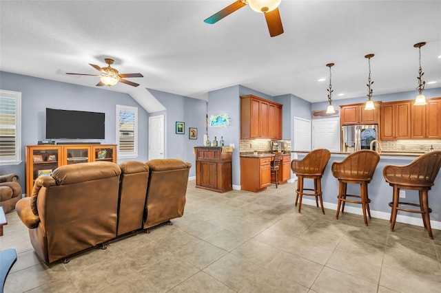 living room with a ceiling fan, baseboards, and light tile patterned floors