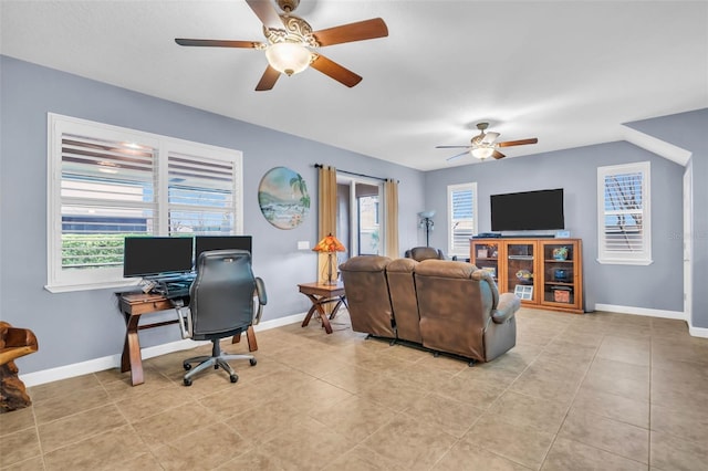 living area featuring baseboards, light tile patterned flooring, and a healthy amount of sunlight