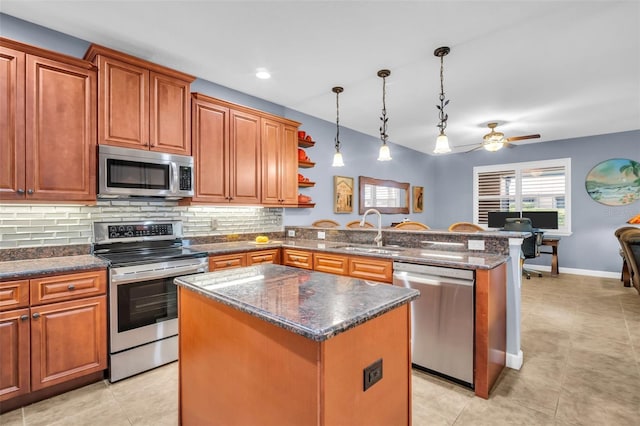 kitchen featuring a kitchen island, pendant lighting, stainless steel appliances, and a sink