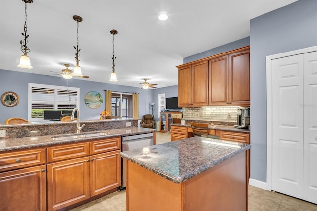 kitchen featuring brown cabinetry, dishwasher, a kitchen island, pendant lighting, and a sink