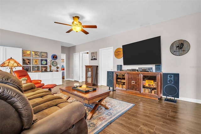 living area with wood finished floors, a ceiling fan, and baseboards