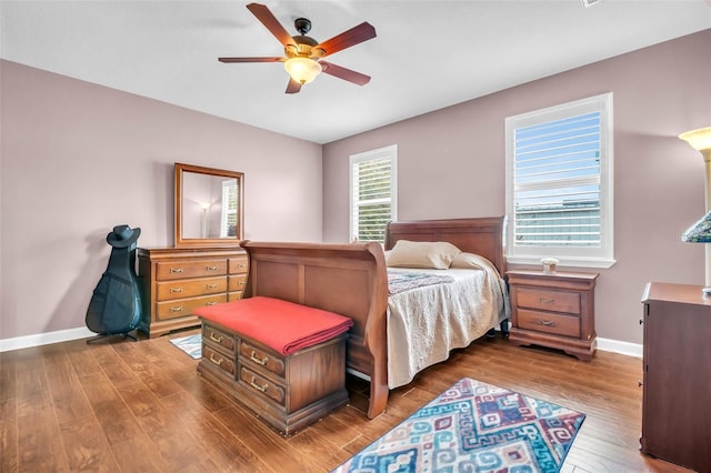 bedroom featuring ceiling fan, wood finished floors, and baseboards