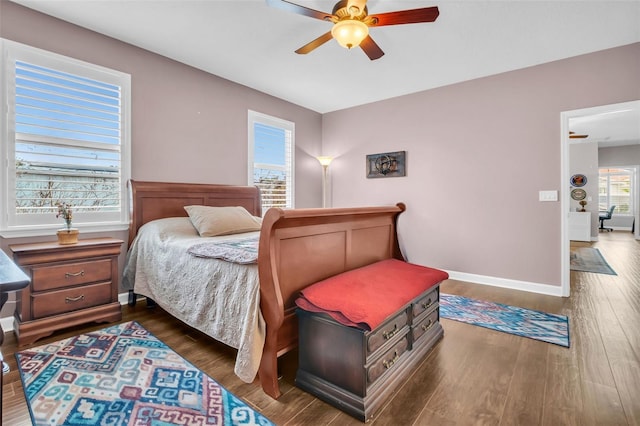 bedroom featuring dark wood-style floors, a ceiling fan, and baseboards