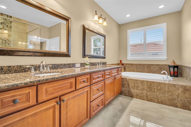 bathroom featuring tile patterned floors, a garden tub, a sink, and double vanity