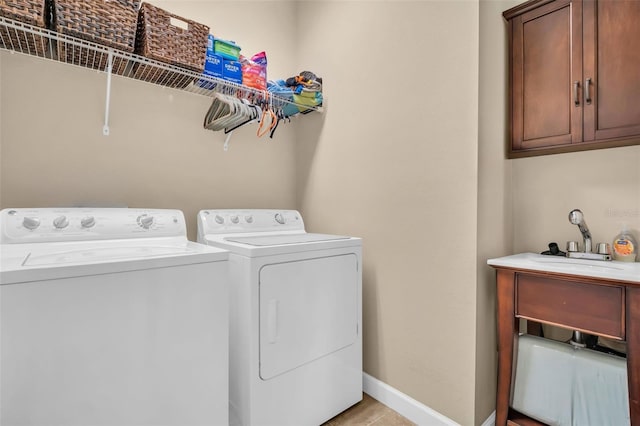 laundry area with independent washer and dryer, cabinet space, and baseboards