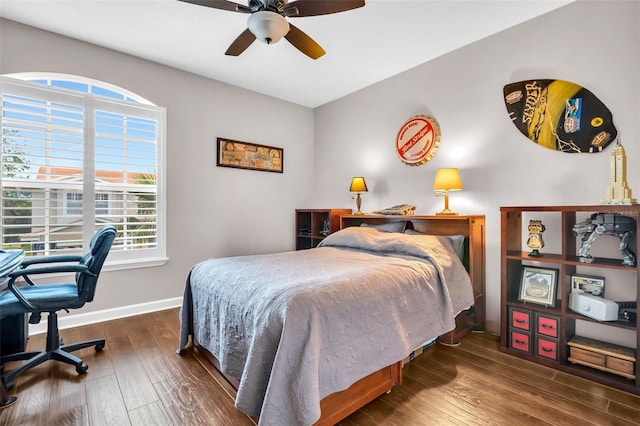 bedroom with ceiling fan, dark wood-type flooring, and baseboards