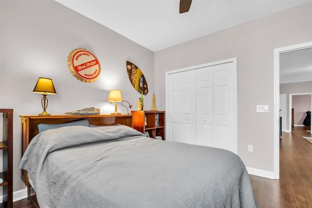 bedroom with dark wood-style floors, a closet, a ceiling fan, and baseboards