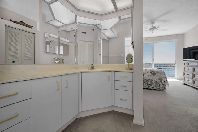 bathroom featuring a textured ceiling, ceiling fan, and vanity