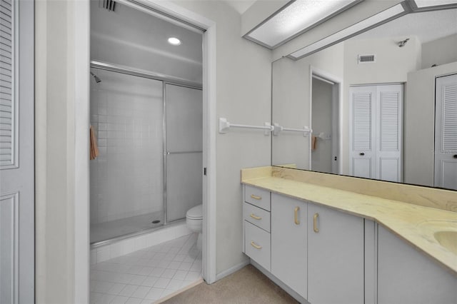 bathroom featuring tile patterned floors, toilet, vanity, and an enclosed shower