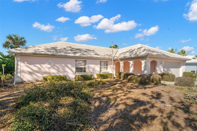 ranch-style home with a garage and stucco siding