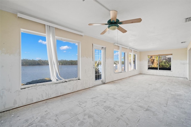 unfurnished sunroom featuring a water view, ceiling fan, and visible vents