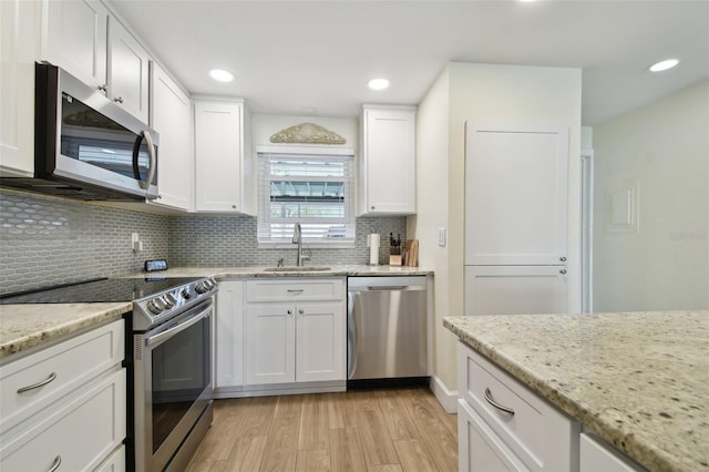 3717 46th Ave S Unit 7, Saint Petersburg, FL 33711 - kitchen featuring white cabinetry, appliances with stainless steel finishes, sink, and light stone counters