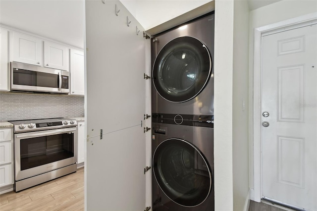 3717 46th Ave S Unit 7, Saint Petersburg, FL 33711 - clothes washing area featuring light hardwood / wood-style floors and stacked washer and clothes dryer