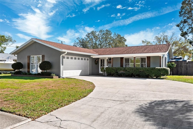 ranch-style house featuring stucco siding, a front yard, fence, a garage, and driveway