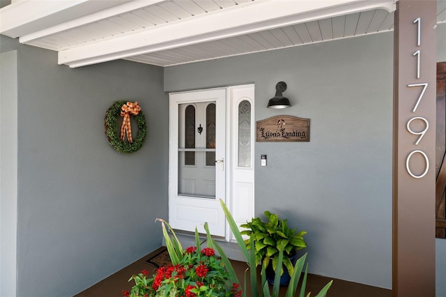 doorway to property featuring stucco siding