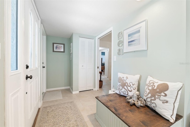 hallway featuring light tile patterned floors and baseboards