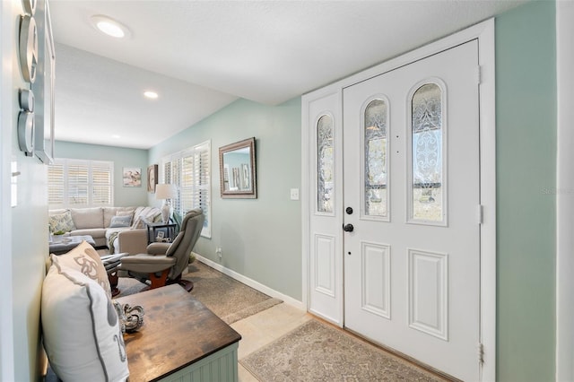 foyer entrance with light tile patterned floors, baseboards, and recessed lighting