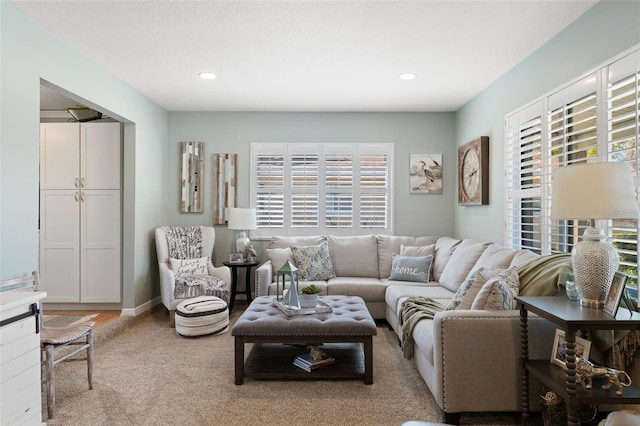 living area with recessed lighting, light carpet, and baseboards