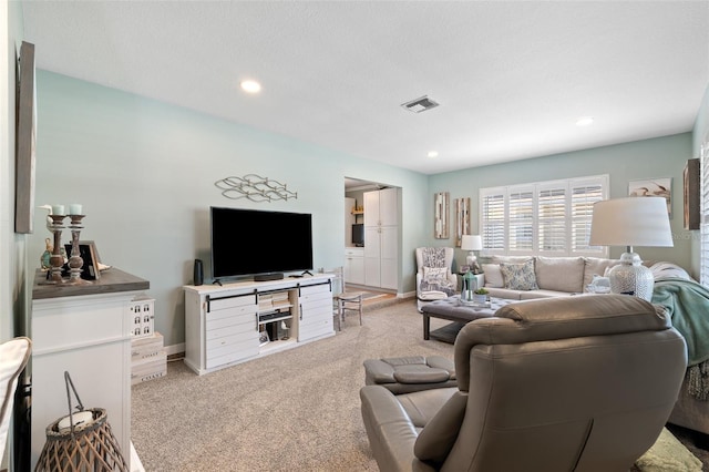 living room featuring light carpet, baseboards, visible vents, and recessed lighting