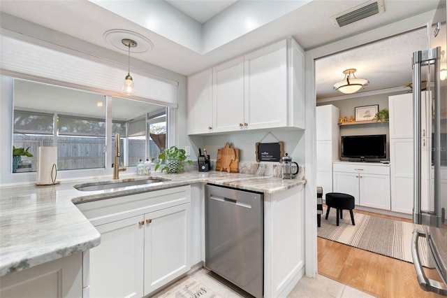 kitchen featuring visible vents, stainless steel dishwasher, a sink, and white cabinetry