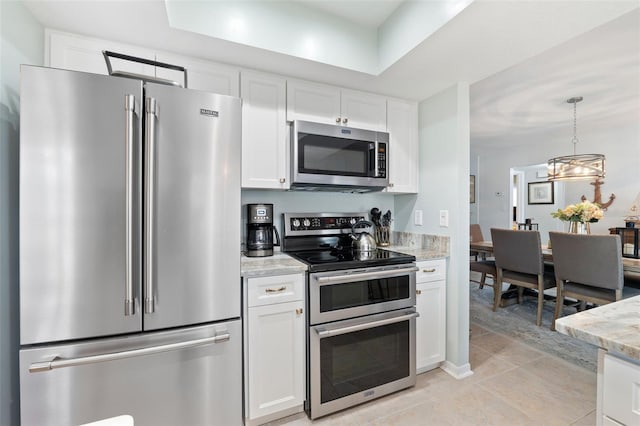 kitchen featuring appliances with stainless steel finishes, light tile patterned flooring, light stone counters, and white cabinets