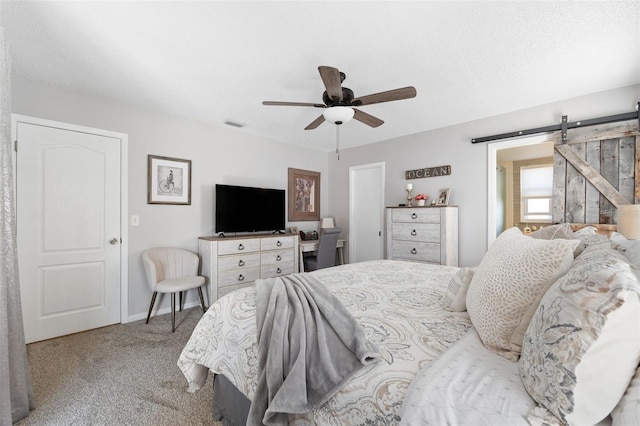 bedroom featuring light carpet, a barn door, baseboards, and ceiling fan