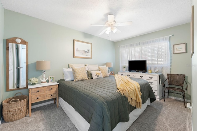 bedroom featuring carpet floors, a textured ceiling, baseboards, and a ceiling fan