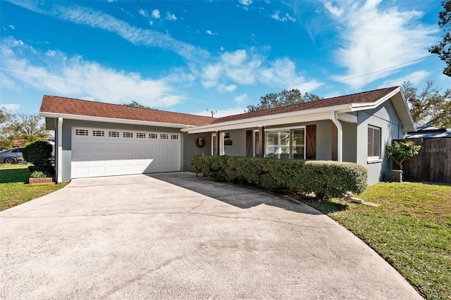 single story home with driveway, a front yard, an attached garage, and stucco siding